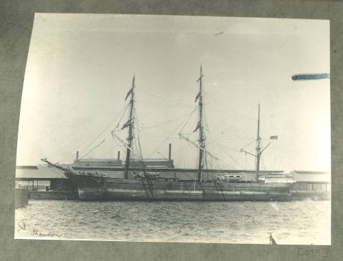 Full-rigged ship docked at a wharf