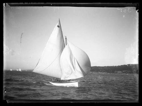 Gaff-rigged sloop with bowsprit sails well ahead of fleet in light winds and headsail is collapsing