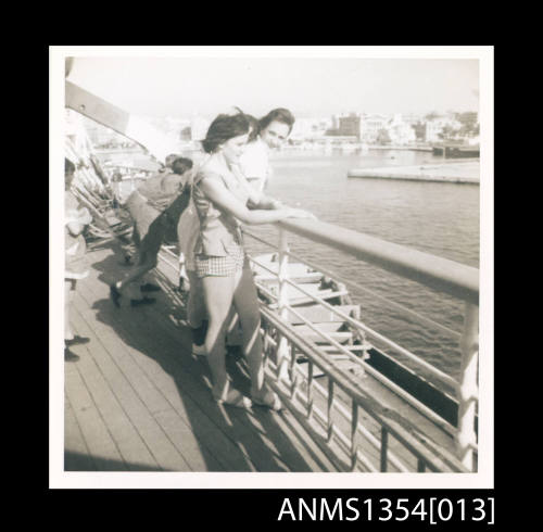 Photograph of two girls from Barnardo's party at ship's rail on SS STRATHEDEN