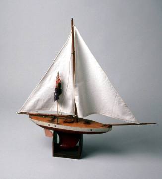 Wooden toy yacht with solid timber hull and metal keel, copper rudder and boom crutch and two cotton sails with australian flag