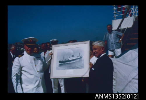 Slide depicting Captain Dun bring presented with a framed picture of the NERITOPSIS