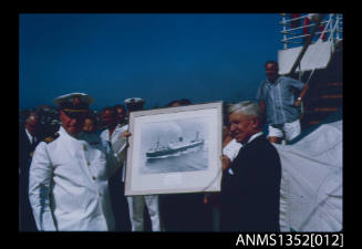 Slide depicting Captain Dun bring presented with a framed picture of the NERITOPSIS