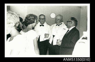 Captain Dun and two unidentified male passengers at a cocktail party onboard SS ARAMAC