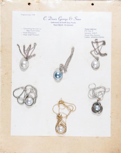 An album page with six half pearl (or mabe pearl) necklaces, attached with string