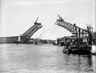 View of Sydney Harbour Bridge under construction with SS CANBERRA passing beneath