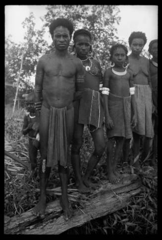 View of local residents standing in a row on a log  