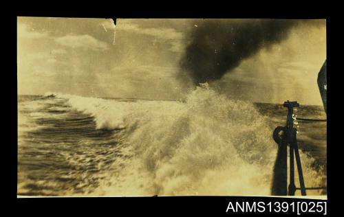 Photograph depicting a rough sea with black smoke coming from the ship's funnel