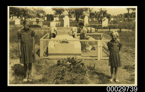 A woman and children visiting a cemetery