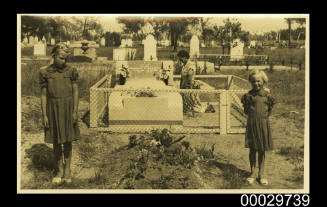 A woman and children visiting a cemetery
