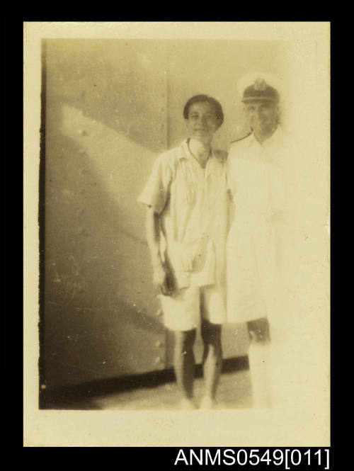 Photograph depicting two men in uniform on board a ship