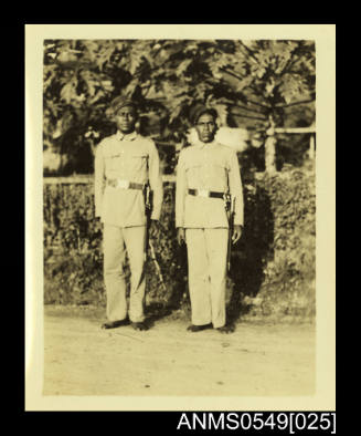 Photograph depicting two men wearing uniform and no shoes