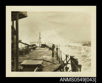 Photograph depicting a view of a ship's deck in rough waters