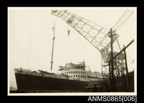 Photograph of KANIMBLA's foremast being lowered by crane into position