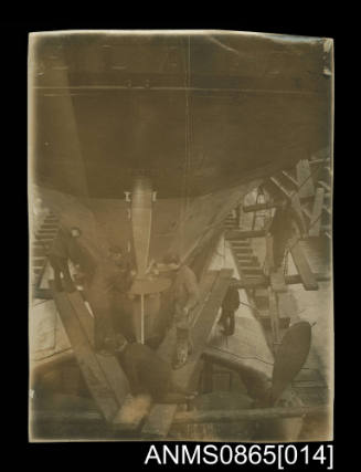 Photograph depicting stern view of a twin screw steamer in dry dock