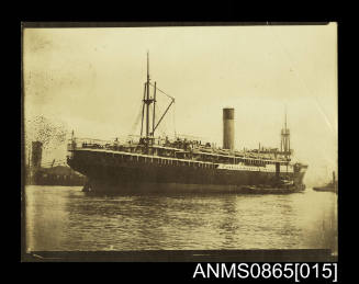 Photograph depicting vessel approaching berth with tug along starboard side