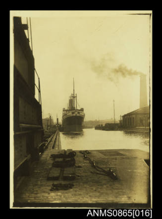 Photograph depicting vessel approaching berth with tug along starboard side