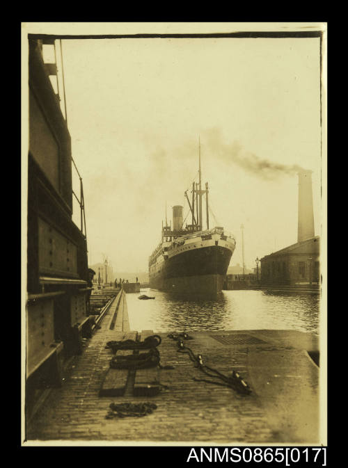 Photograph depicting vessel approaching berth with tug along starboard side