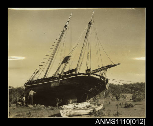 Photograph of the FLYING FOAM careened in mangroves being repaired