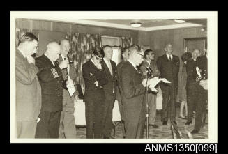 Captain Dun with group of people watching a speech