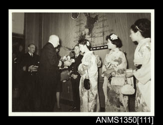 Captain Dun presenting a toy koala to a woman