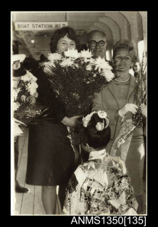 Photograph of a woman being presented with flowers