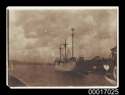 Three masted wooden ship alongside a wharf