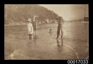 Four children playing in the shallow water of Sheltered bay in Sydney Harbour