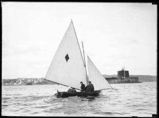 18-foot skiff with a diamond-shaped sail insignia, sails past Fort Denison