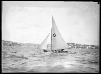 Gaff -rigged skiff  WONGA with square within a square as sail insignia sailing on main harbour