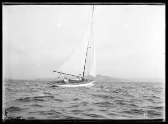 Classic sloop sailing on Harbour  with crew standing on leeward deck