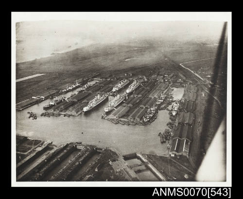 Aerial view of passenger liners SS BELGENLAND, SS ORFORD, SS ORONTES and SS OTRANTO docked beside wharves