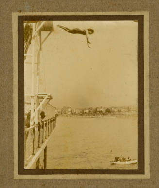 Beatrice Kerr diving from a platform above a pier