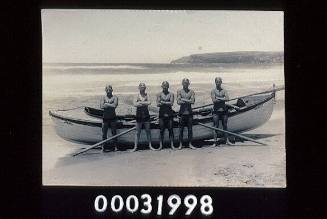 SURFBOAT AKUBRA ON BEACH WITH 5 MEMBERS OF QUEENSCLIFF SURF LIFE SAVING CLUB SURFBOAT CREW POSED INFRONT