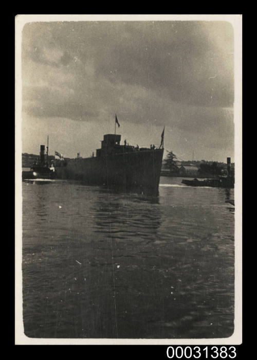 Royal Australian Navy ship with tugboats