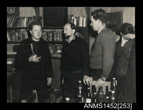 Mr. Aubrey Gotley, leader of the party which spent 14 months on Heard Island, hands over to Mr. Andrew Garriock, the new officer-in-charge while Mr. Phillip Law, leader of the Australian National Antarctic Research Expedition, supervises the change-over