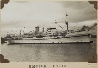 Photograph  EMPIRE PRIDE depicting starboard side of passenger ship [trooper] in harbour with tugs off bow and stern