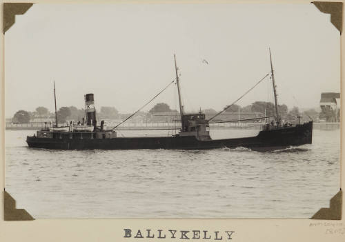 Photograph  BALLYKELLY depicting  starboard  side view of cargo ship under way off retaining wall on the port side