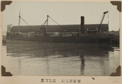 Photograph of  KYLE QUEEN depicting port side of cargo  ship berthed at wharf on starboard side