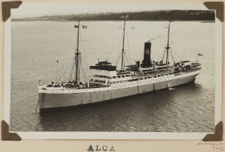 Photograph of ALCA depicting the port side of passenger ship  at anchor at sea with distant hills on stern and starboard side