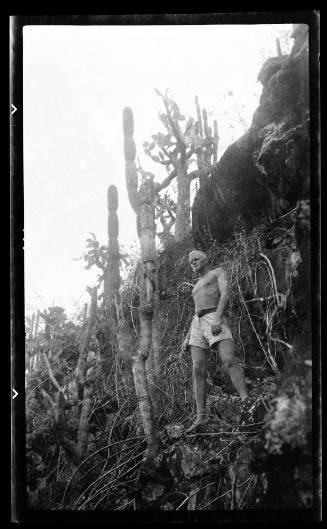 Richard Nossiter standing barefoot on a cacti covered cliff, Galapagos Islands