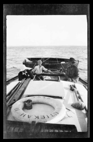 Boy holding the tiller on yacht UTIEKAH II, other crew beside him