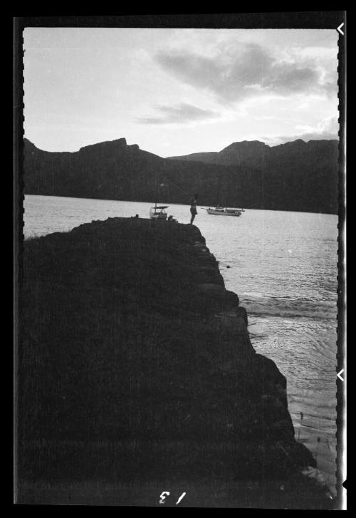 A man stands at the top of a rocky promontory on Nuku Hiva Island