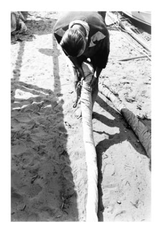 Untitled (man rolling a sail)