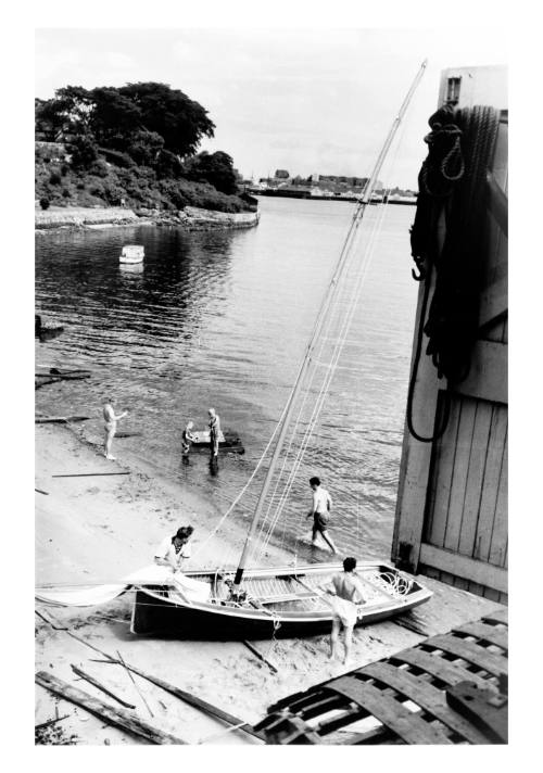 Beached 18-foot skiff near a boatshed