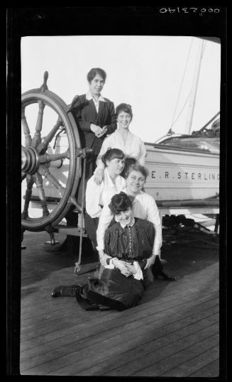 Five unidentified women next to the ship's wheel on board E R STERLING