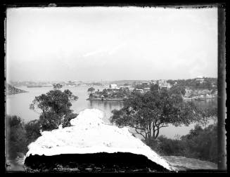 Sydney Harbour, New South Wales, with city buildings and a three masted ship at anchor seen in the background