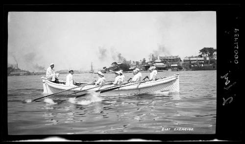 Cadets in uniform rowing a boat