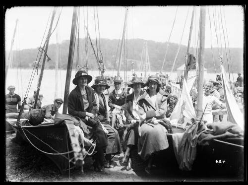 Women sitting on beached skiffs at the Pittwater Regatta