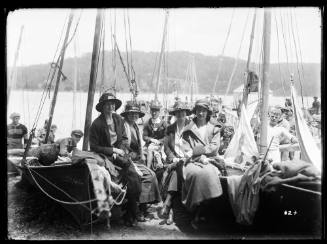 Women sitting on beached skiffs at the Pittwater Regatta