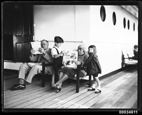 Man and woman reading to children possibly on board SS ORMISTON